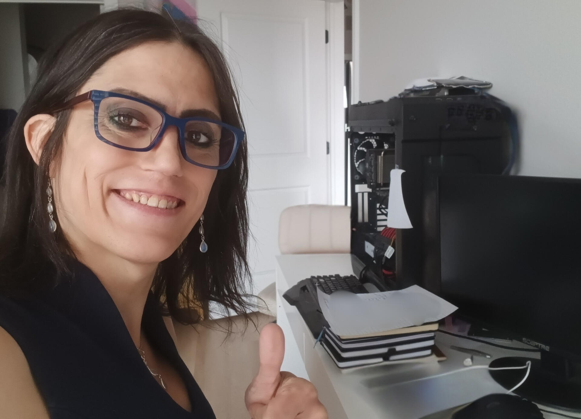 Erin Bennett, Co-Founder and CISO of SECRT LLC, smiling at her desk with computer equipment in the background.